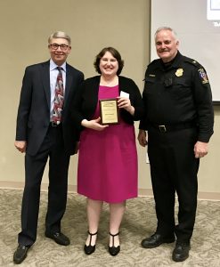 Picture of Elyse Grossman standing between two Montgomery County officials, as she holds the Montgomery County, Maryland Keeping it Safe (KIS) Community Service Award.